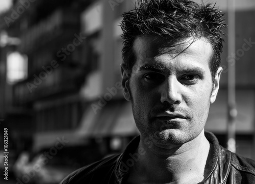 Handsome man portrait in the city shadows black and white