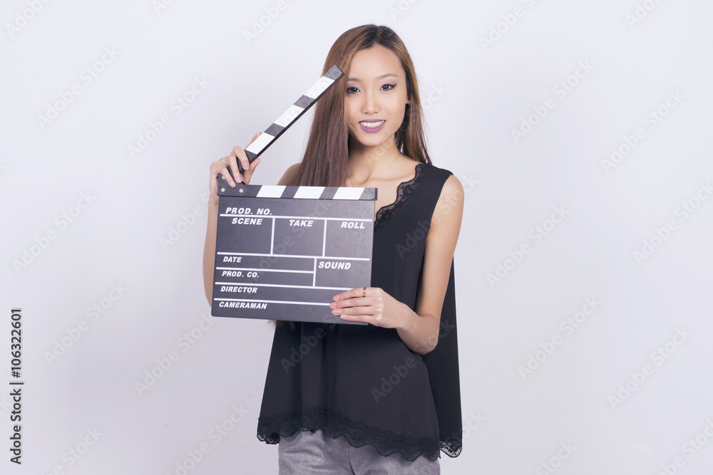 Happy asian woman holding a cinema clapper board. Happy asian woman holding a cinema clapper board.