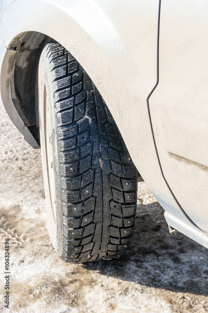Winter Tire on a Grey Car in Sunlight Winter Tire on a Grey Car in Sunlight
