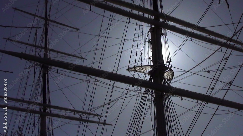 Sun flare through sailing ship masts silhouette