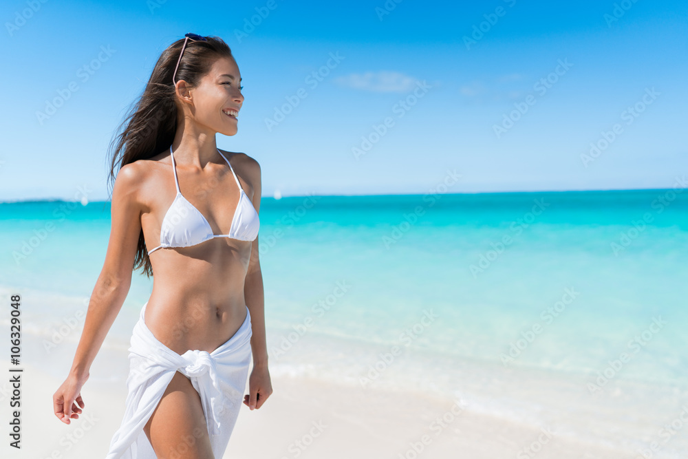 Bikini woman relaxing in white sun protection beachwear walking on tropical  Caribbean beach with turquoise ocean water during summer vacations. Happy  lifestyle Asian girl. Stock Photo | Adobe Stock