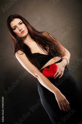 Beautiful woman holds red heart on black