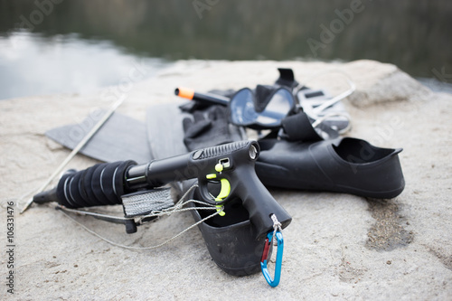 Equipment for underwater hunting near the pond on the rock.