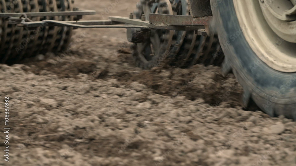 Agricultural tractor sowing and cultivating field Agricultural tractor sowing and cultivating field