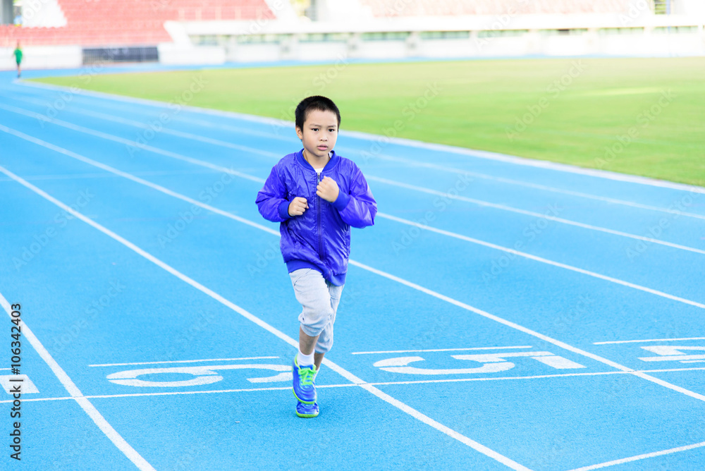 Fototapeta premium Boy runnin on blue track