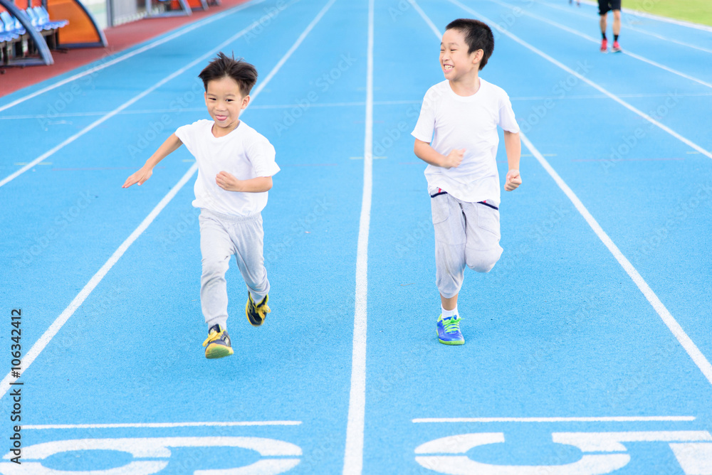 Fototapeta premium Boy runnin on blue track