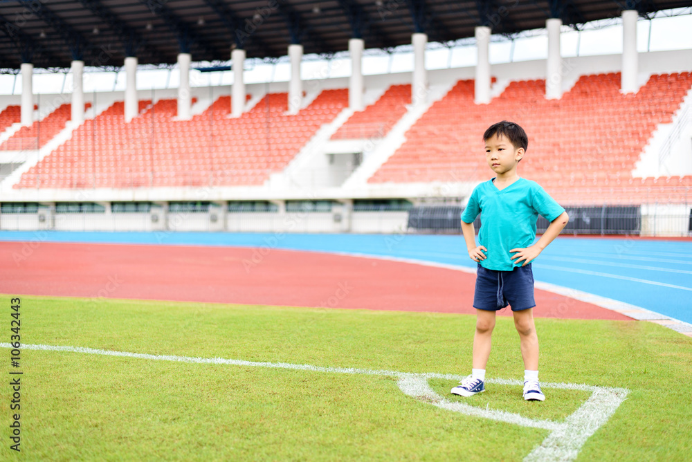 Boy stand on the football field.