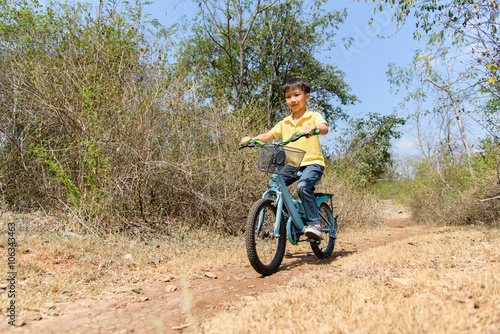 Little boy ride bicycle on the rock road.