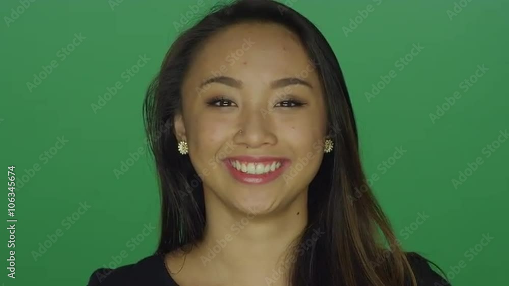 Beautiful young woman laughing and smiling, on a green screen studio background Beautiful young woman laughing and smiling, on a green screen studio background