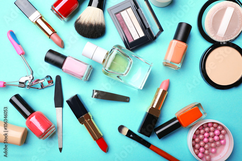 Decorative makeup cosmetics and manicure tools on turquoise background