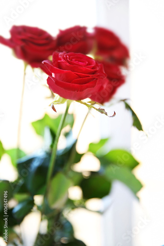 Bouquet of fresh red roses on windowsill background