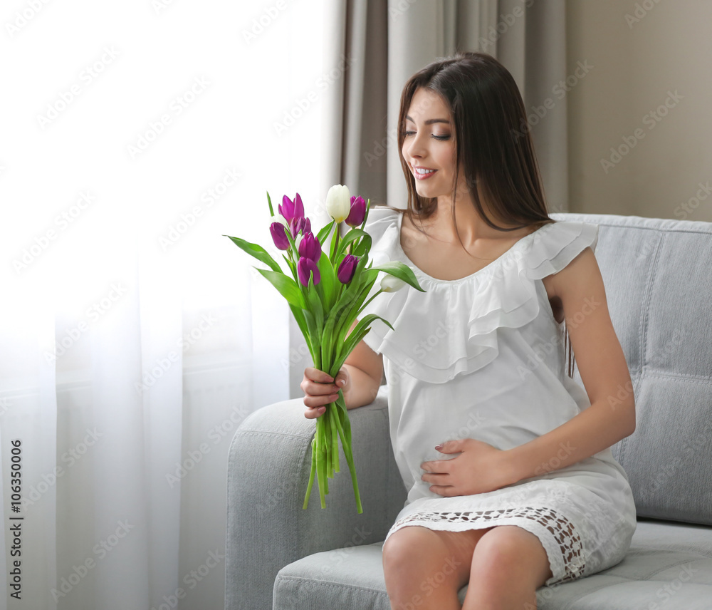 Pregnant woman with beautiful bouquet of tulips in the room Pregnant woman with beautiful bouquet of tulips in the room