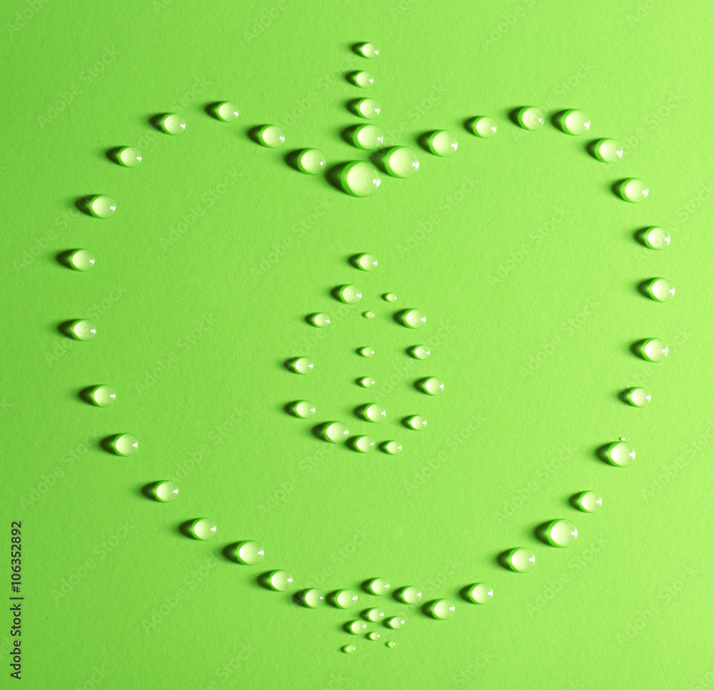 Half of apple made of water drops on green background Half of apple made of water drops on green background