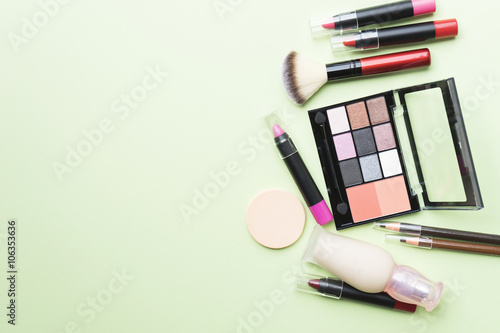 Set of colorful cosmetics on green background
