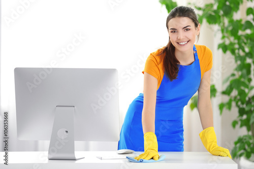 Young woman cleaning workpl...