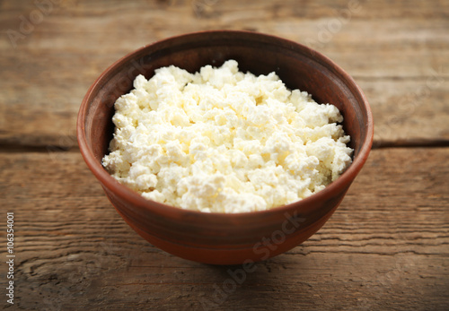 Bowl of cottage cheese on wooden table