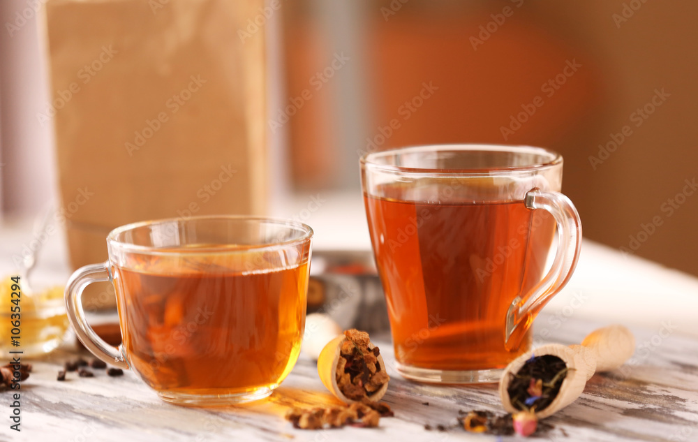 Glass cup of tea with spices on blurred background Glass cup of tea with spices on blurred background