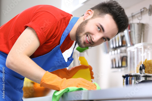 Man cleaning stove in the k...