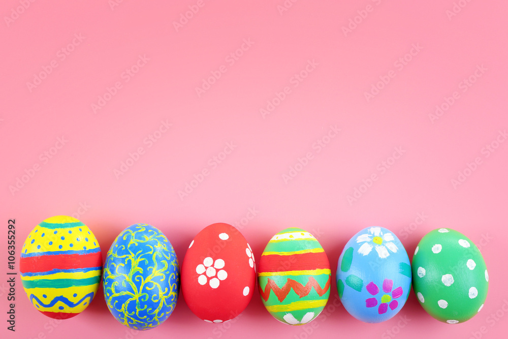 Multicoloured Easter eggs on pink background, top view