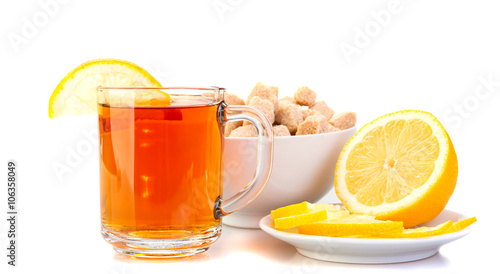 cup of black tea with lemon, lemon on a saucer, brown sugar.