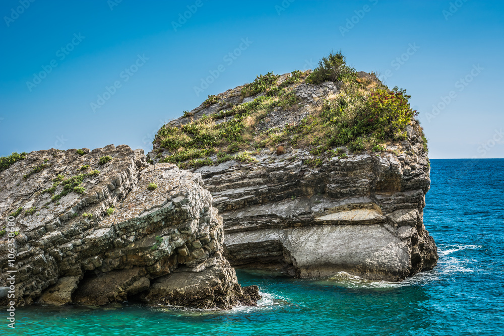 Summer in Budva, Montenegro. / Interesting rocks on Island of St. Nicholas and beautiful Adriatic sea in Budva during summer time, in Montenegro