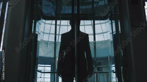 Businessman out of a glass elevator