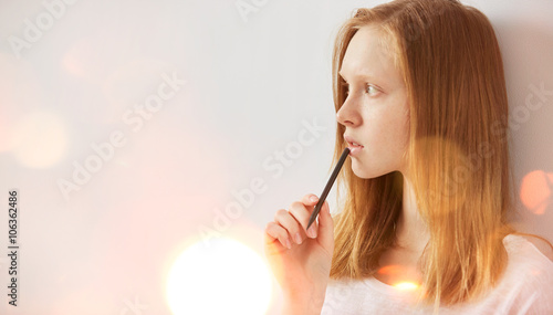 Young girl writing into her notebook in the park