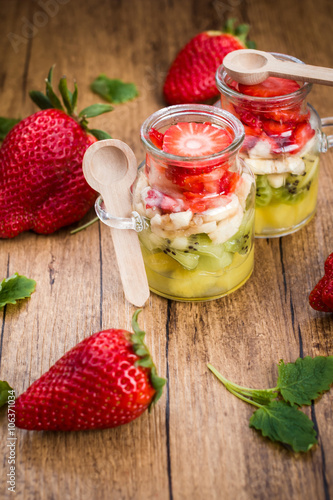 Homemade fruit salad in jars on a wooden background