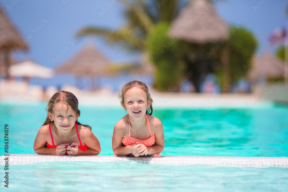 Adorable little girls playing in outdoor swimming pool Adorable little girls playing in outdoor swimming pool