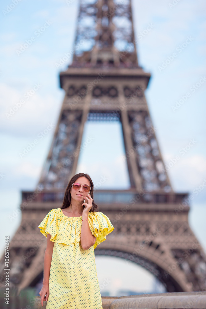 Fototapeta premium Young woman talking by phone background Eiffel Tower in Paris