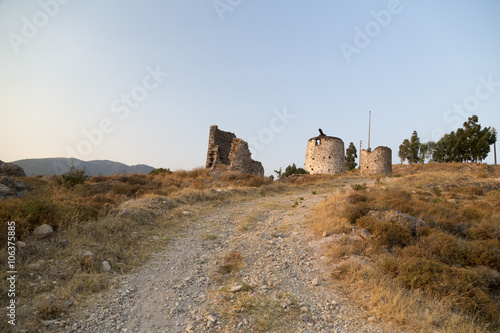 Sunset scene at the ruins of the historical Aegean stone windmills in Ortakent, Bodrum located in southwest Turkey. photo