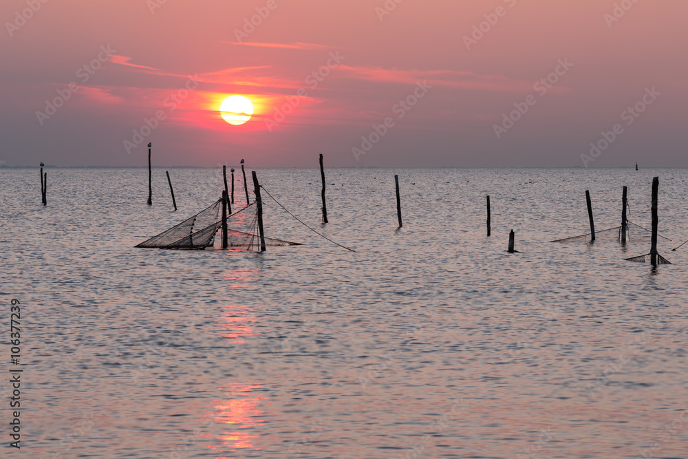 Sunset over Dutch sea with fishing nets