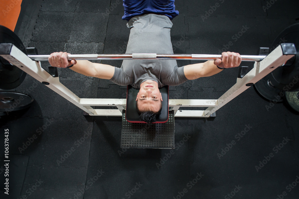 Young Man In Gym Exercising Chest On The Bench Press - top view Stock Photo  | Adobe Stock