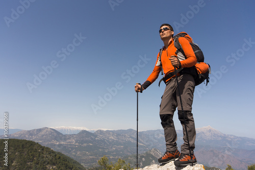 Young man with backpack on a mountain top on a sunny day. © trek6500