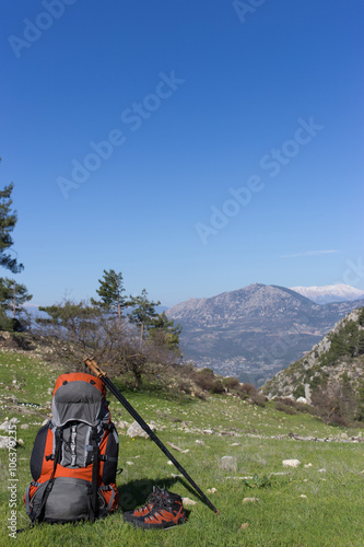 Camping with backpack in the mountains on a sunny summer day.