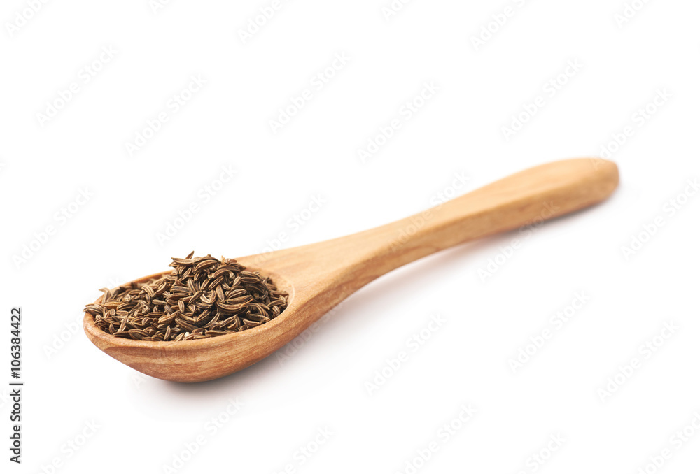 Wooden spoon full of cumin seeds Wooden spoon full of cumin seeds