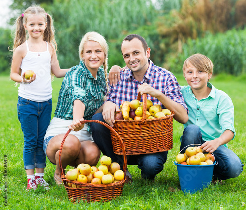 Parents and children with baskets of apples