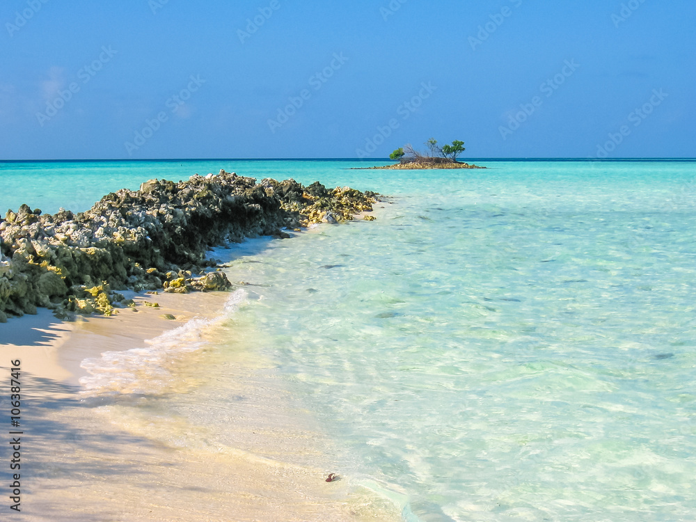 Obraz premium Maldives background, Indian Ocean. Turquoise water of the lagoon paradise. Rocks in the sea and coral reef. North Male Atoll Asdu.
