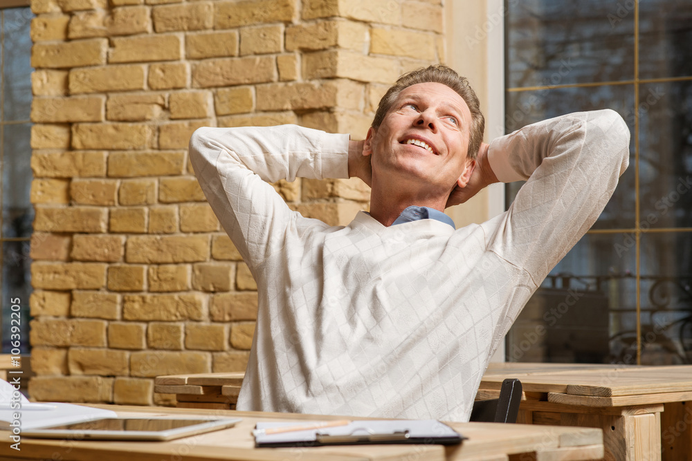 Pleasant man stretching at the table Pleasant man stretching at the table