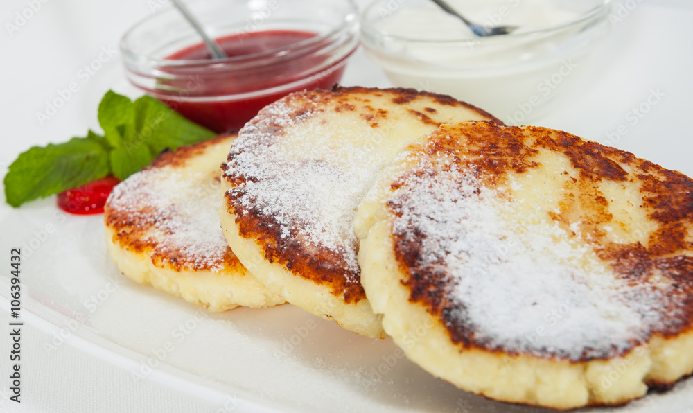 cheese pancakes with sour cream and strawberry sauce cheese pancakes with sour cream and strawberry sauce