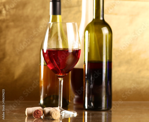 wine bottle and wine glass on a glass table