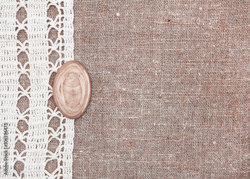Vintage background with lace on the old burlap