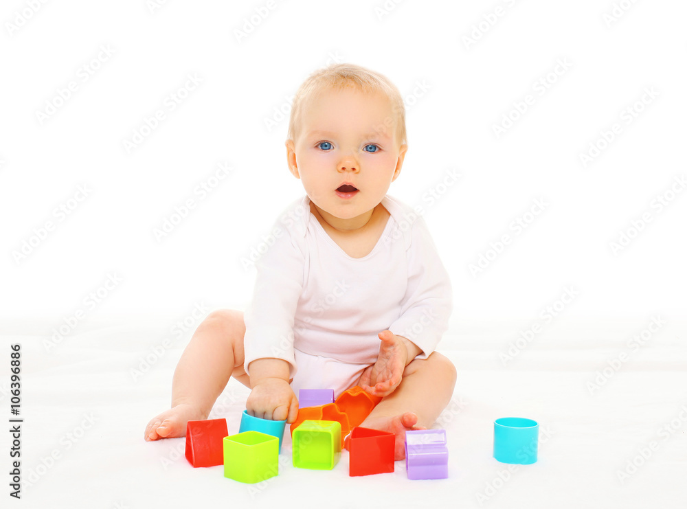 Baby playing with colorful toys on a white background Baby playing with colorful toys on a white background