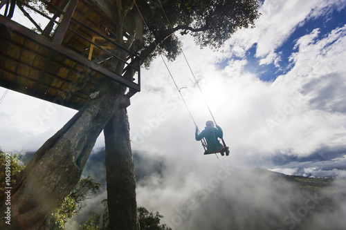 girl swinging in ecuador mountains  against sun