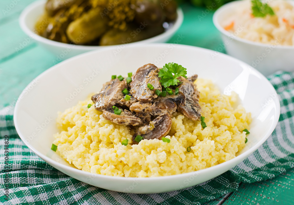 Millet porridge with mushrooms in a white bowl Millet porridge with mushrooms in a white bowl
