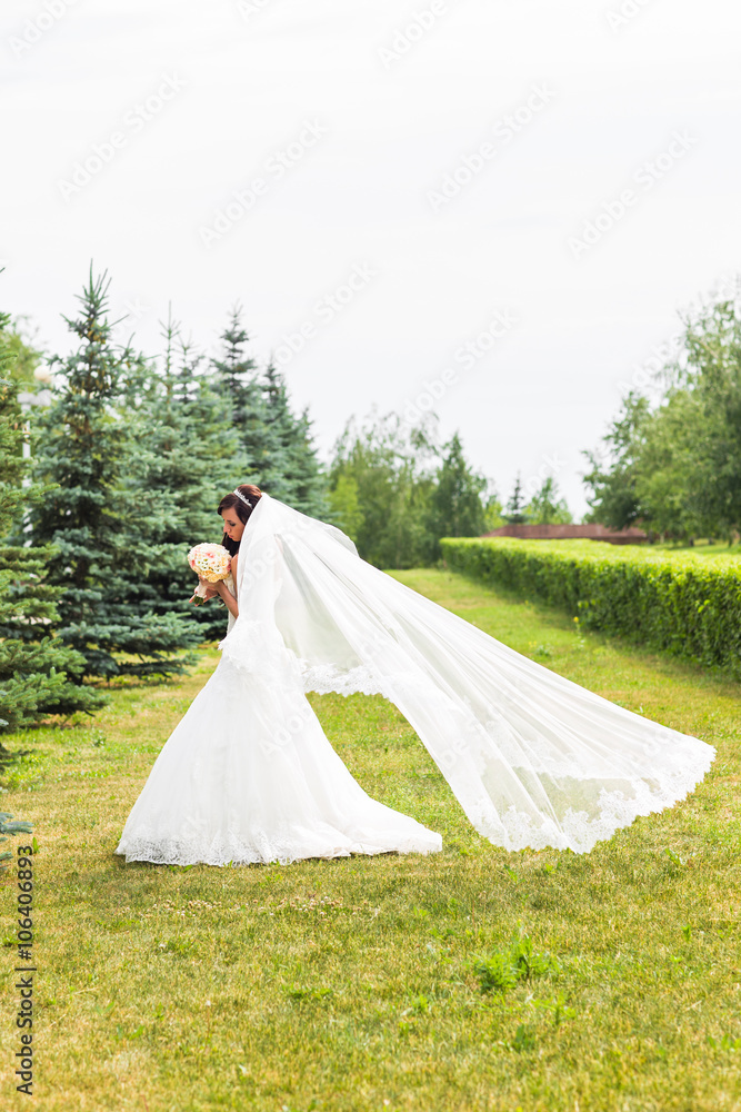 Fototapeta premium Beautiful bride with bouquet of flowers outdoor