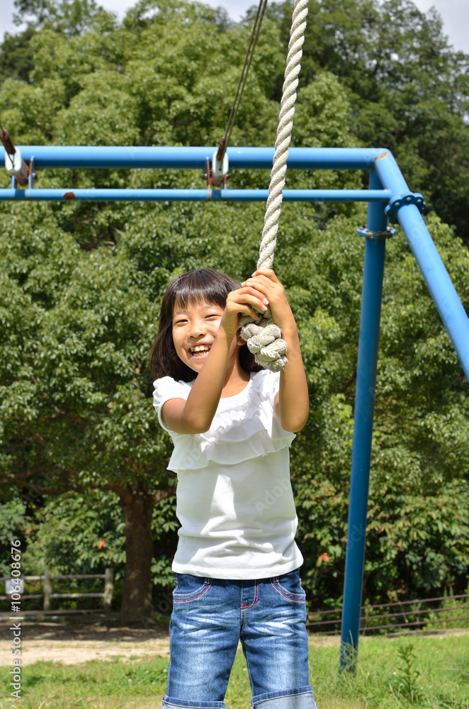 公園の遊具で楽しく遊ぶ女の子