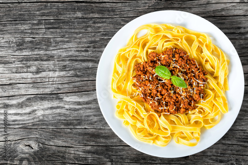 Billede på lærred Bolognese ragout with italian pasta on a white plate, close-up