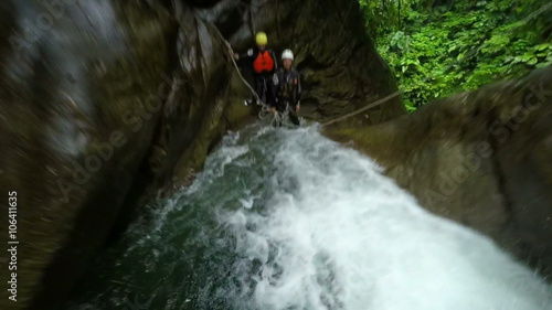 Experience the exhilarating first person view of a breathtaking waterfall jump during an adrenaline pumping canyoning adventure in the lush Ecuadorian rainforest,captured on a handheld action camera.