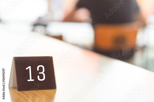 number 13 queue on wooden table blurred man background